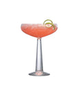 NUDE Big Top Coupe glass with linear patterned stem filled with cocktail