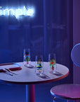 Lifestyle image of NUDE Mirage Rock & Pop collection  in neon table scenery