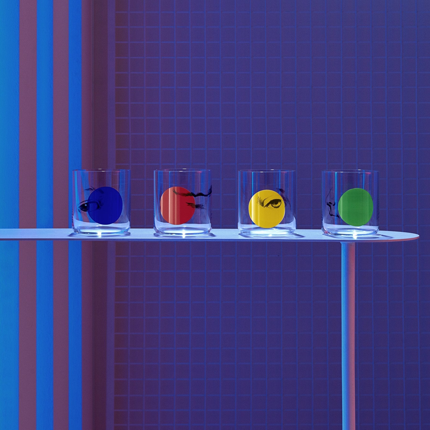 Lifestyle image of NUDE Rock & Pop glass collection with jug, highball glass and whisky glass in dark neon environment