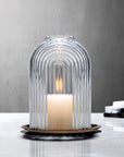 Lead-free crystal candle holder Ilo, a dome shaped candle holder with rippled glass effect, with candle presented on a table with grey tones