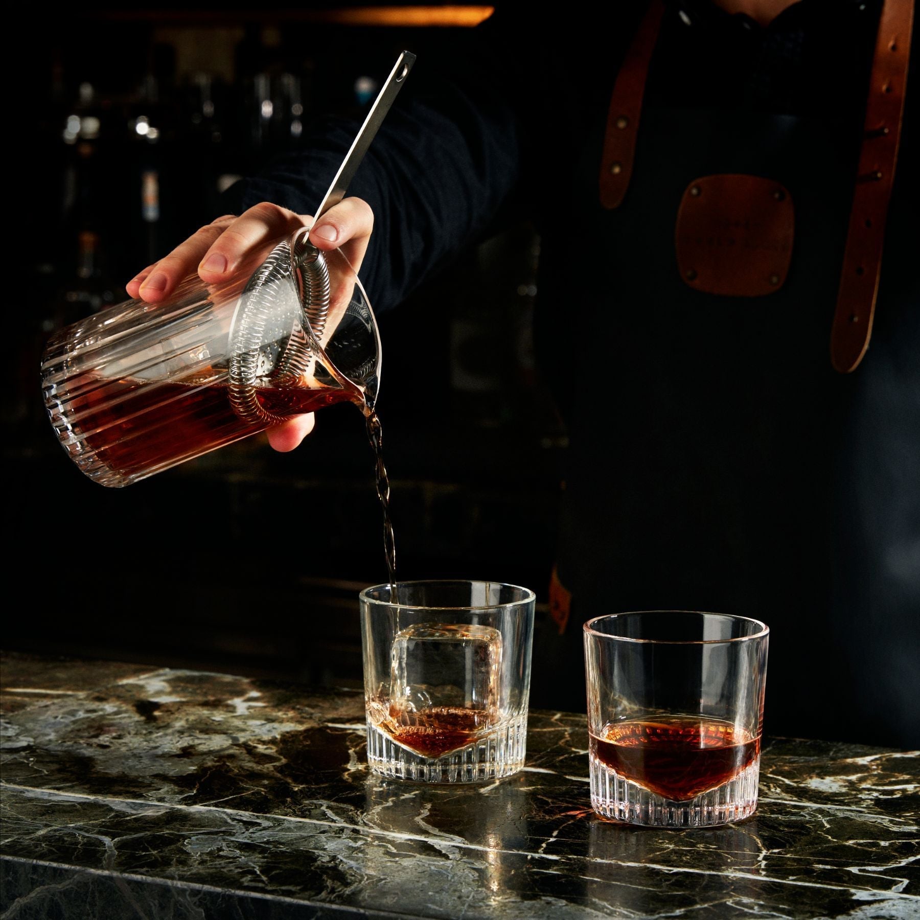 NUDE Caldera whisky glass filled being filled by mixologist in bar